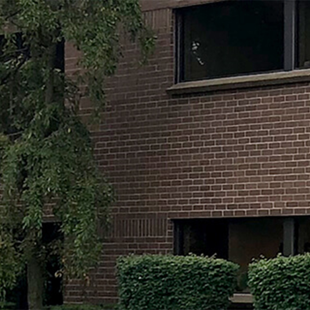 A building with brown bricks and bushes