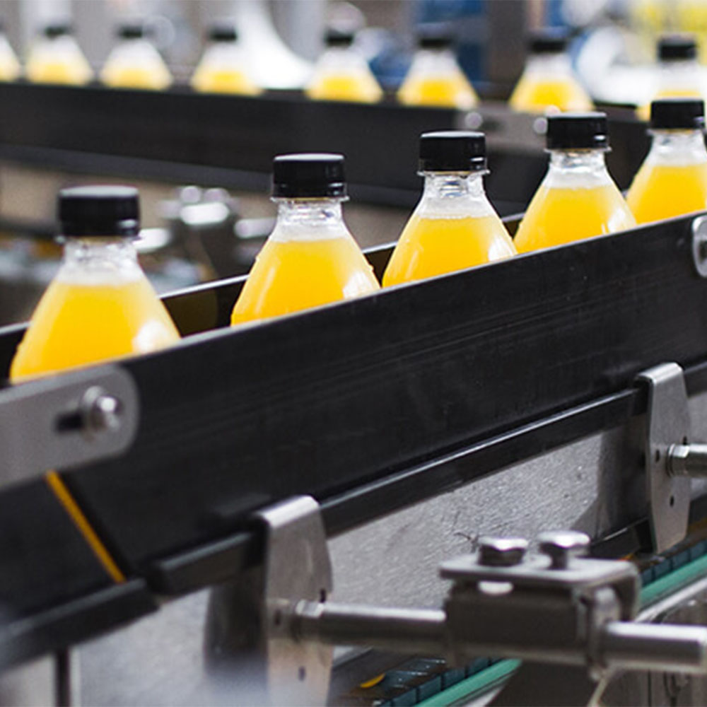 Bottles with lids moving down a conveyor belt.